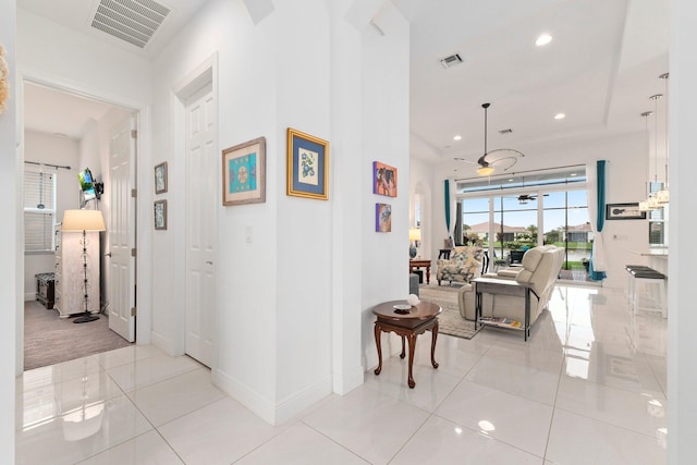 corridor featuring recessed lighting, visible vents, baseboards, and light tile patterned floors