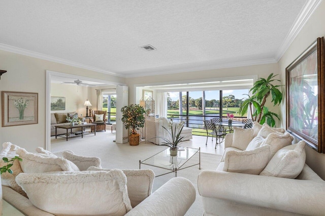 living area featuring light carpet, a textured ceiling, visible vents, and crown molding