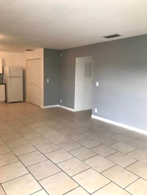 spare room with light tile patterned floors, visible vents, and baseboards