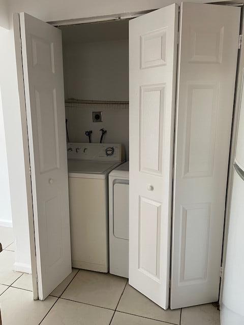 laundry area featuring light tile patterned floors, laundry area, and independent washer and dryer