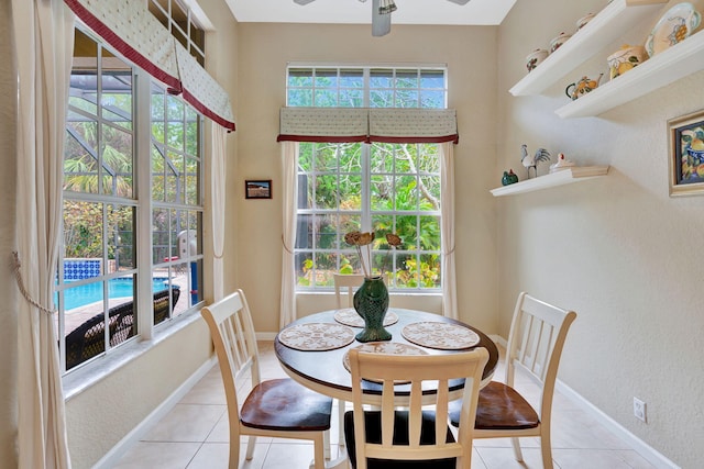 dining space featuring ceiling fan, light tile patterned flooring, and baseboards