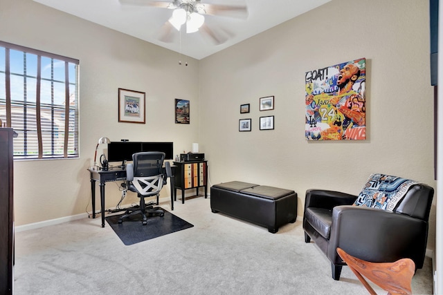 office space featuring a ceiling fan, light carpet, and baseboards