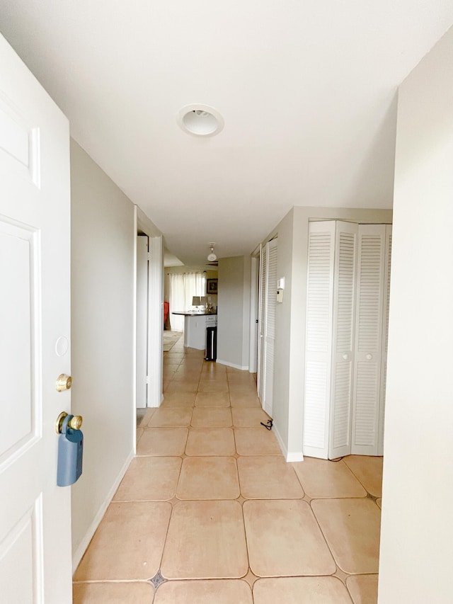 hall with light tile patterned floors and baseboards