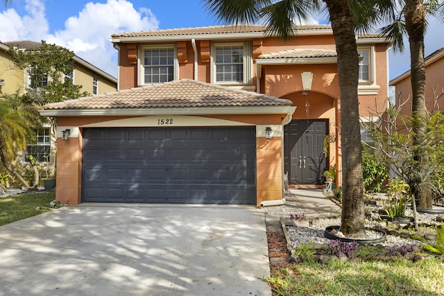 view of front of house with a tiled roof, an attached garage, driveway, and stucco siding