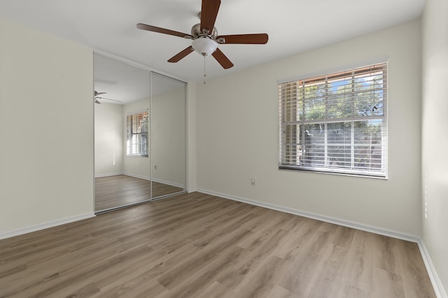 unfurnished room featuring ceiling fan, wood finished floors, and baseboards