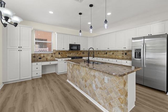 kitchen featuring a center island with sink, white cabinets, stainless steel fridge with ice dispenser, black microwave, and a sink