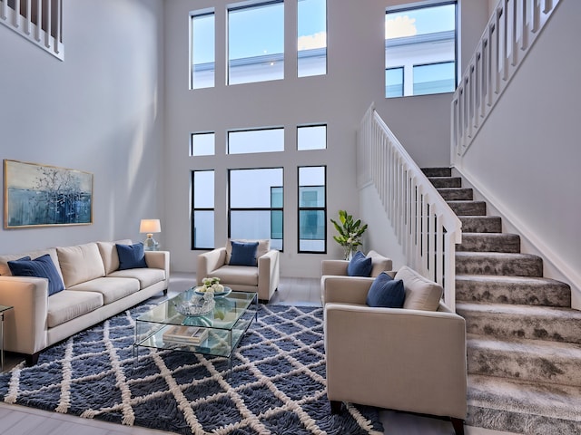 living area featuring plenty of natural light, stairway, and wood finished floors