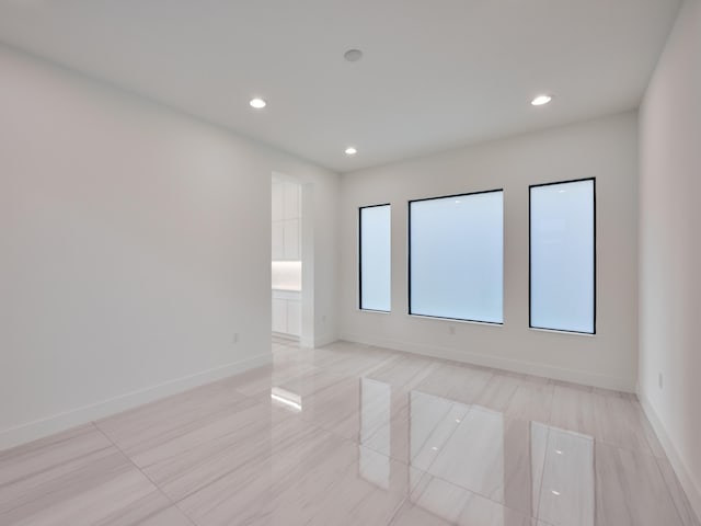 unfurnished room with baseboards and recessed lighting