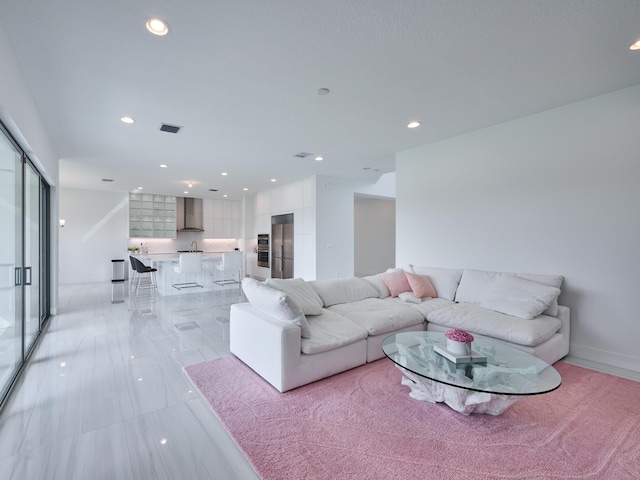 living area with baseboards, visible vents, and recessed lighting