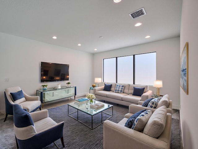 living area with baseboards, visible vents, and recessed lighting