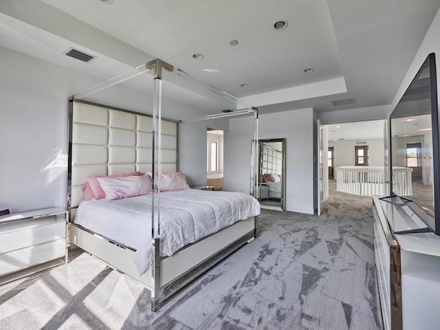 carpeted bedroom with visible vents, a textured ceiling, and baseboards