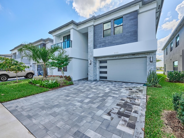 view of front of house featuring a garage, decorative driveway, and stucco siding