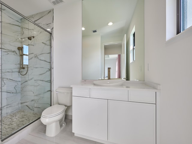 bathroom with a marble finish shower, recessed lighting, visible vents, toilet, and vanity