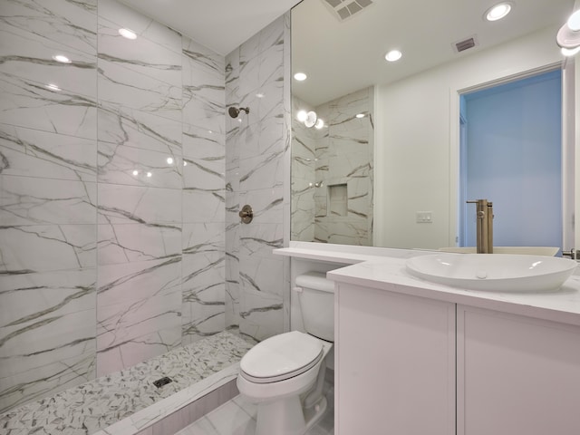 bathroom featuring a marble finish shower, visible vents, and toilet