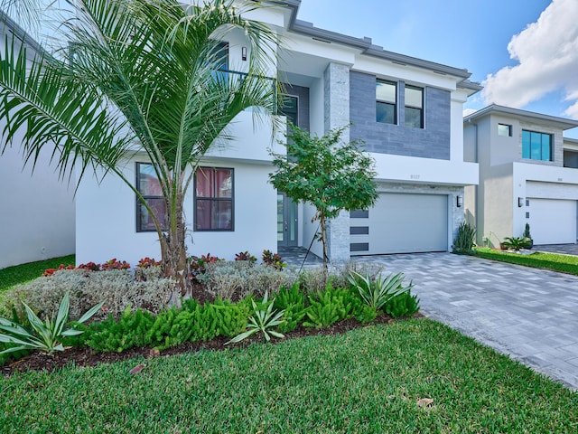 view of front of home with a garage, decorative driveway, and stucco siding