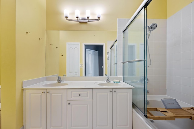 bathroom featuring double vanity, shower / bath combination with glass door, and a sink