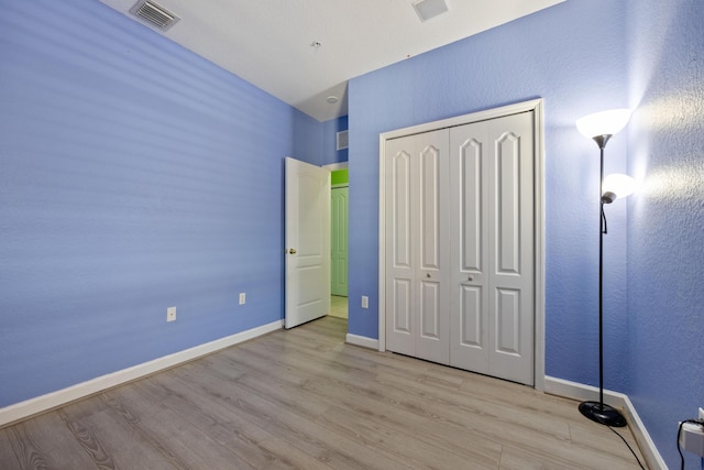 unfurnished bedroom featuring light wood finished floors, baseboards, and visible vents