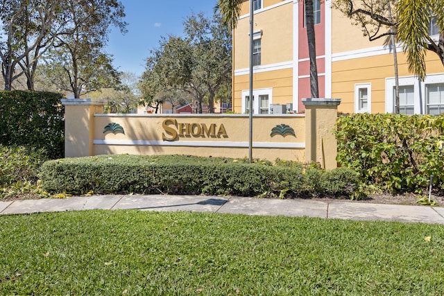 community sign featuring a lawn