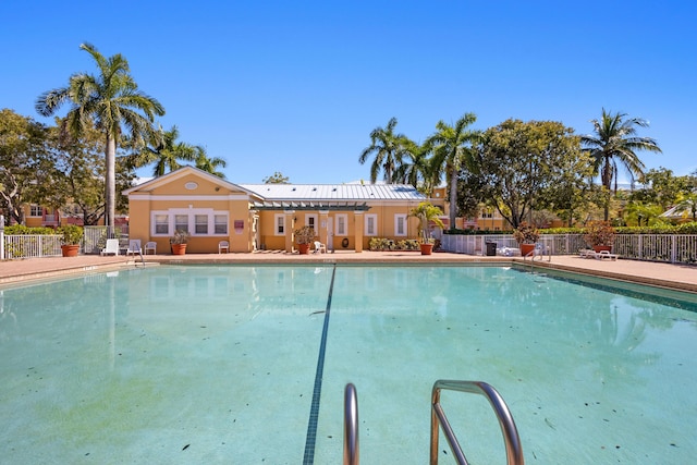 community pool with a patio and fence