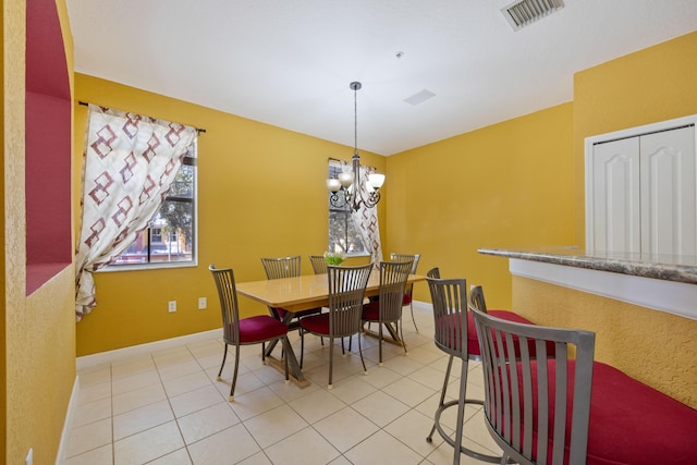 dining area featuring light tile patterned floors, baseboards, visible vents, and a notable chandelier