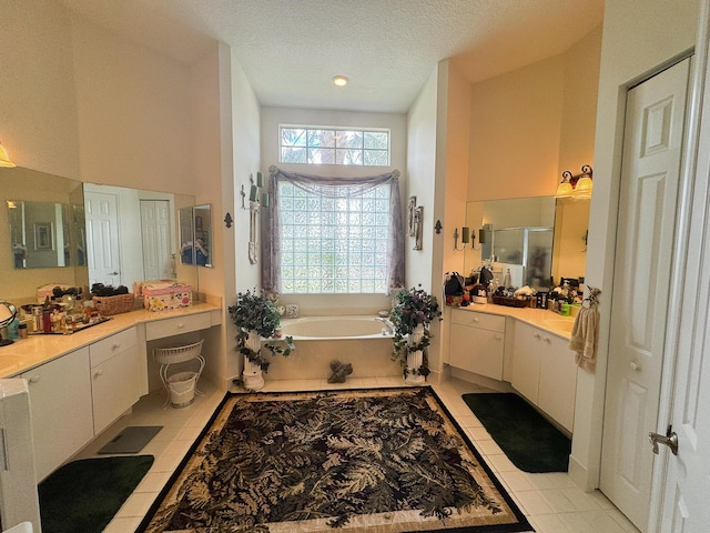 bathroom with vanity, an enclosed shower, a textured ceiling, tile patterned floors, and a bath