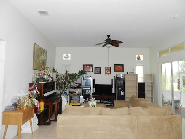 living area featuring visible vents, light tile patterned flooring, and a ceiling fan