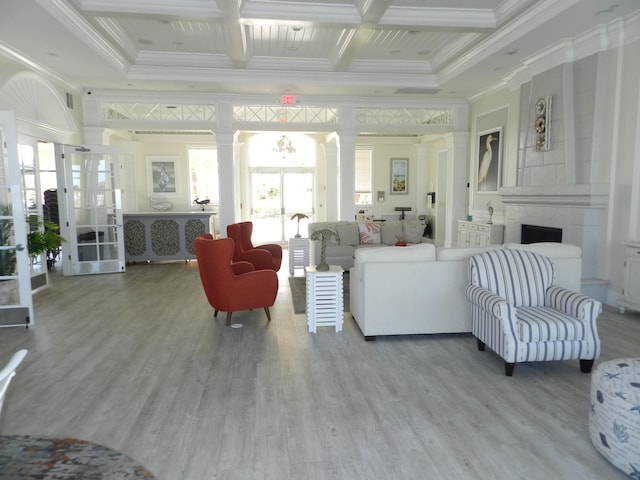 living area with crown molding, decorative columns, wood finished floors, and coffered ceiling