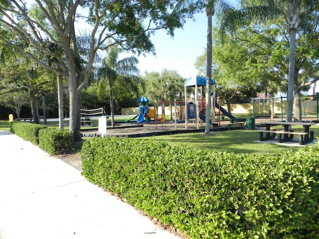 view of property's community featuring playground community and a lawn