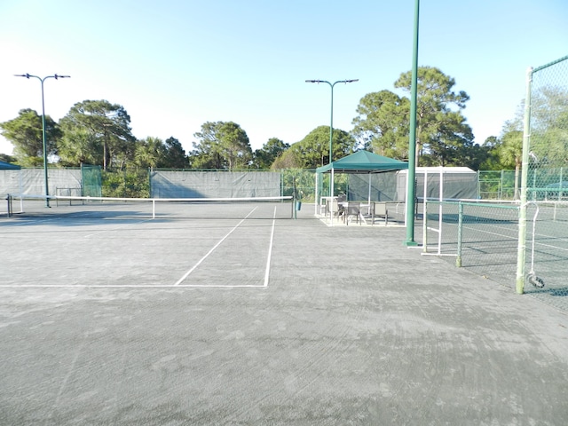 view of tennis court featuring fence