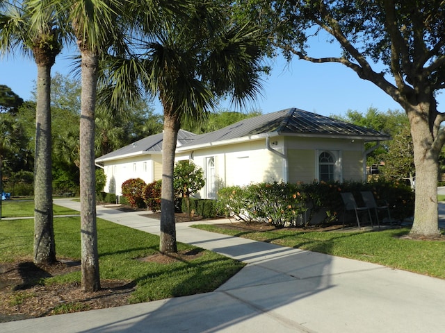 224 NW Pleasant Grove Way, Port Saint Lucie, FL 34986 - view of front of house with metal roof, a front yard, and driveway