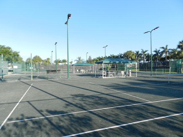 view of tennis court featuring a gazebo and fence