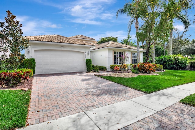 view of front of property featuring stucco siding, a tile roof, an attached garage, decorative driveway, and a front yard