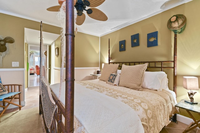 bedroom featuring light tile patterned floors, a ceiling fan, and crown molding