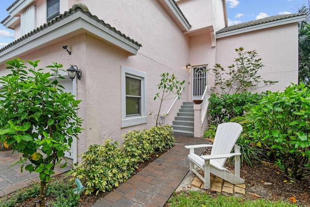 entrance to property with a patio area and stucco siding