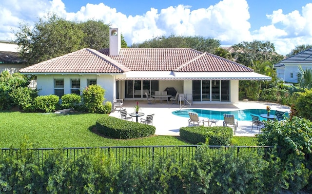 rear view of house with a patio, a tiled roof, a fenced in pool, stucco siding, and a chimney