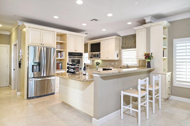 kitchen featuring recessed lighting, stainless steel appliances, a breakfast bar, light stone countertops, and open shelves