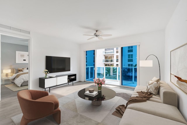 living room featuring ceiling fan, visible vents, and wood finished floors