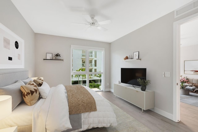 bedroom featuring light wood finished floors, baseboards, visible vents, and ceiling fan