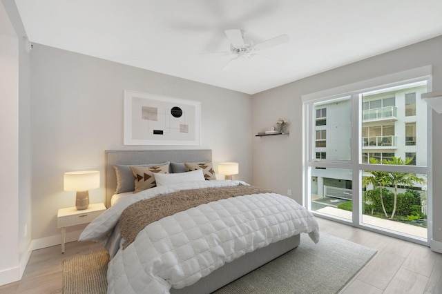 bedroom with a ceiling fan, light wood-style flooring, and baseboards