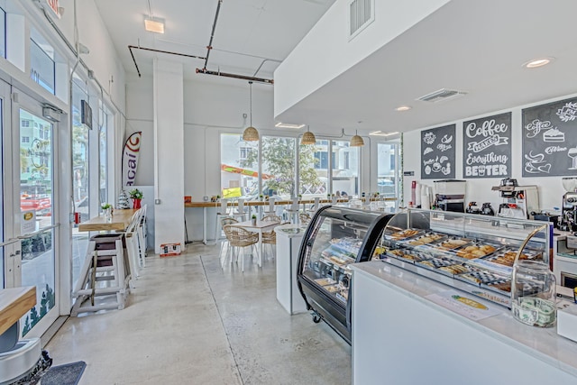 interior space with a wealth of natural light, visible vents, and finished concrete flooring