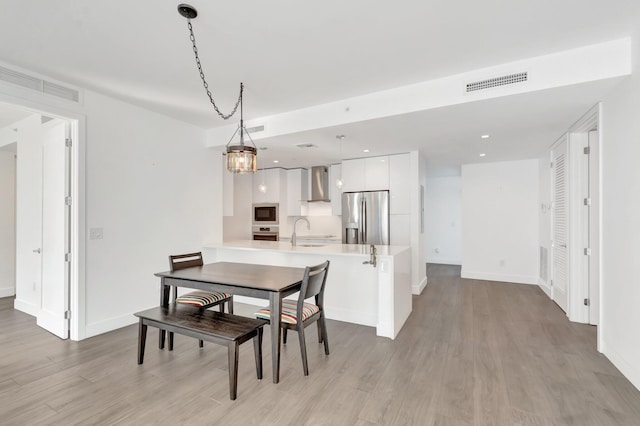 dining room with light wood-style flooring, visible vents, baseboards, and recessed lighting