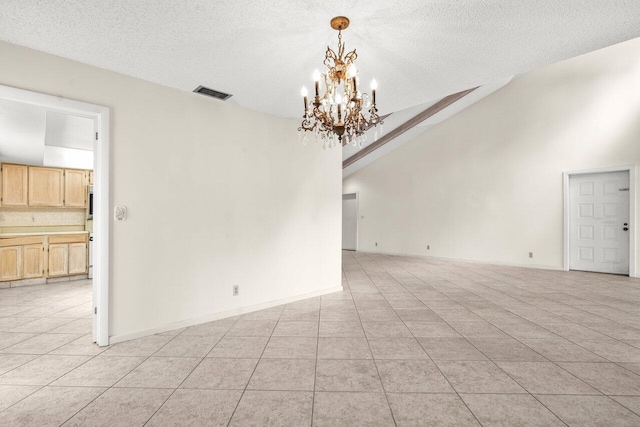 spare room featuring light tile patterned floors, a textured ceiling, a chandelier, and visible vents