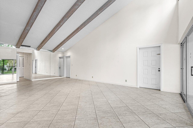 unfurnished living room with light tile patterned floors, high vaulted ceiling, a textured ceiling, baseboards, and beam ceiling