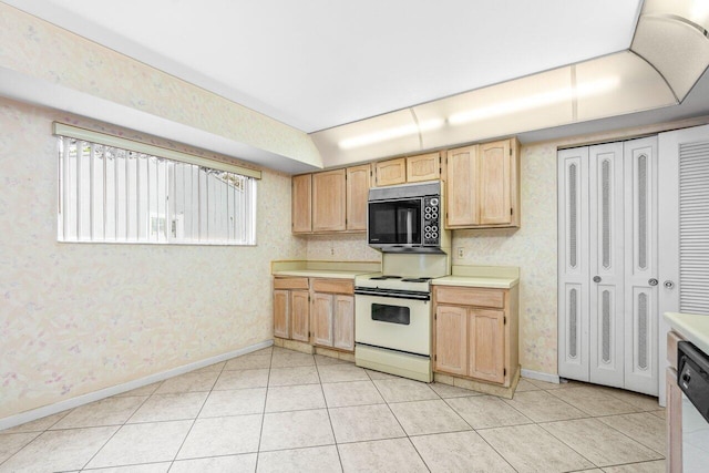 kitchen featuring light tile patterned flooring, electric stove, light countertops, and wallpapered walls