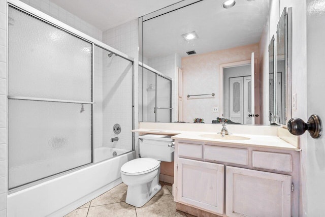 bathroom featuring visible vents, bath / shower combo with glass door, toilet, tile patterned flooring, and vanity