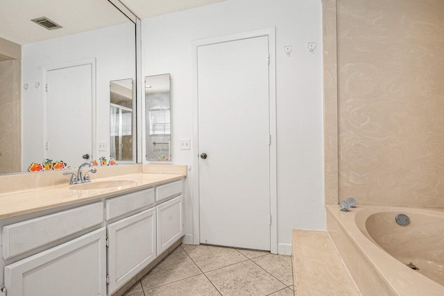 full bathroom featuring visible vents, tile patterned flooring, vanity, and a tub