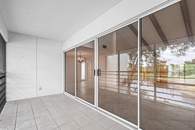 unfurnished sunroom with a wealth of natural light and an inviting chandelier