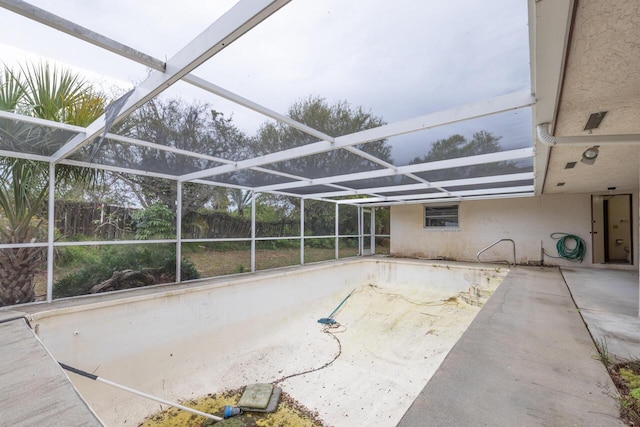 view of patio / terrace featuring glass enclosure and fence