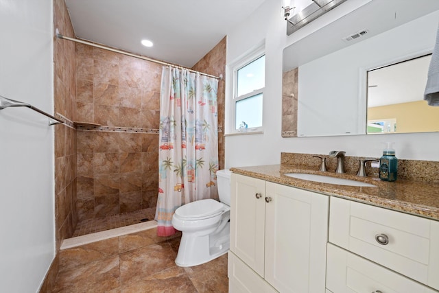 bathroom featuring visible vents, a tile shower, vanity, and toilet