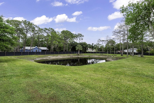 view of yard featuring a water view and fence